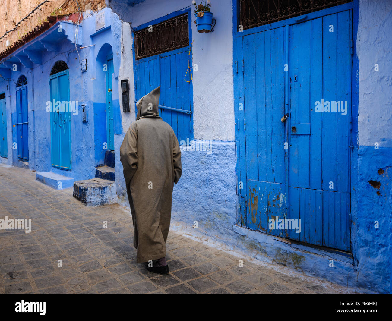 CHEFCHAOUEN, Marocco - circa aprile 2017: marocchina uomo a camminare per le strade di Chefchaouen indossando un djellaba tradizionale Foto Stock