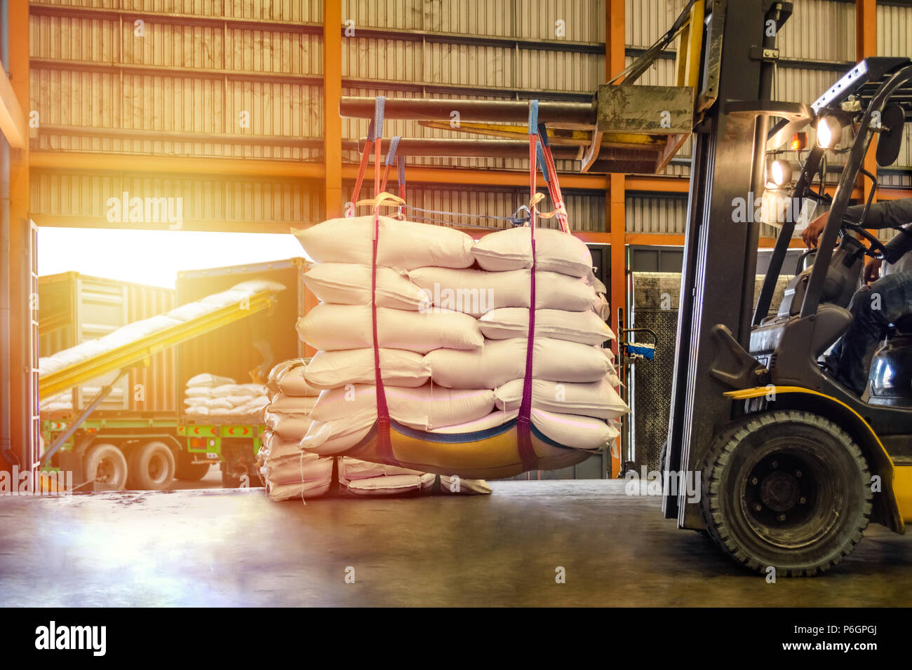 Carrello di movimentazione dello zucchero bianco sacchi per il ripieno in contenitori al di fuori di un magazzino. Distribuzione, Logistica Import Export, concetto di magazzino. Foto Stock