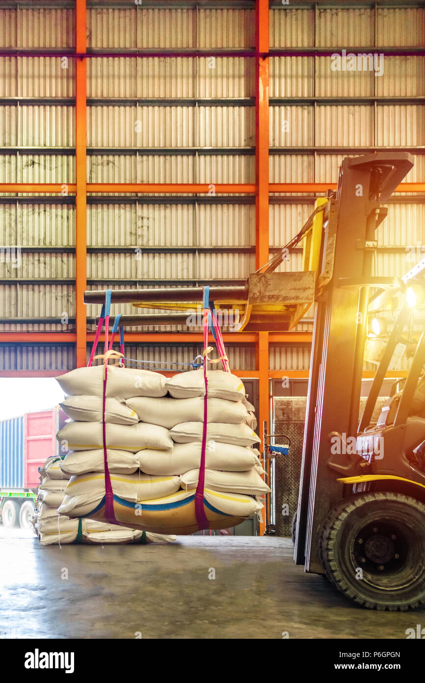 Carrello di movimentazione dello zucchero bianco sacchi per il ripieno in contenitori al di fuori di un magazzino. Distribuzione, Logistica Import Export, concetto di magazzino. Foto Stock