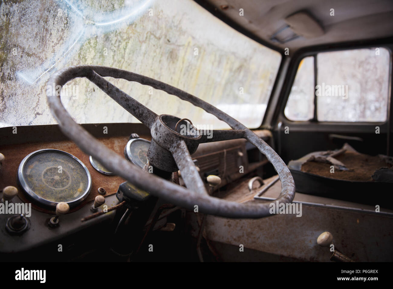 Un vecchio abbandonato vintage auto a sinistra fuori nei boschi. Soffre di decadimento e ruggine. Foto Stock