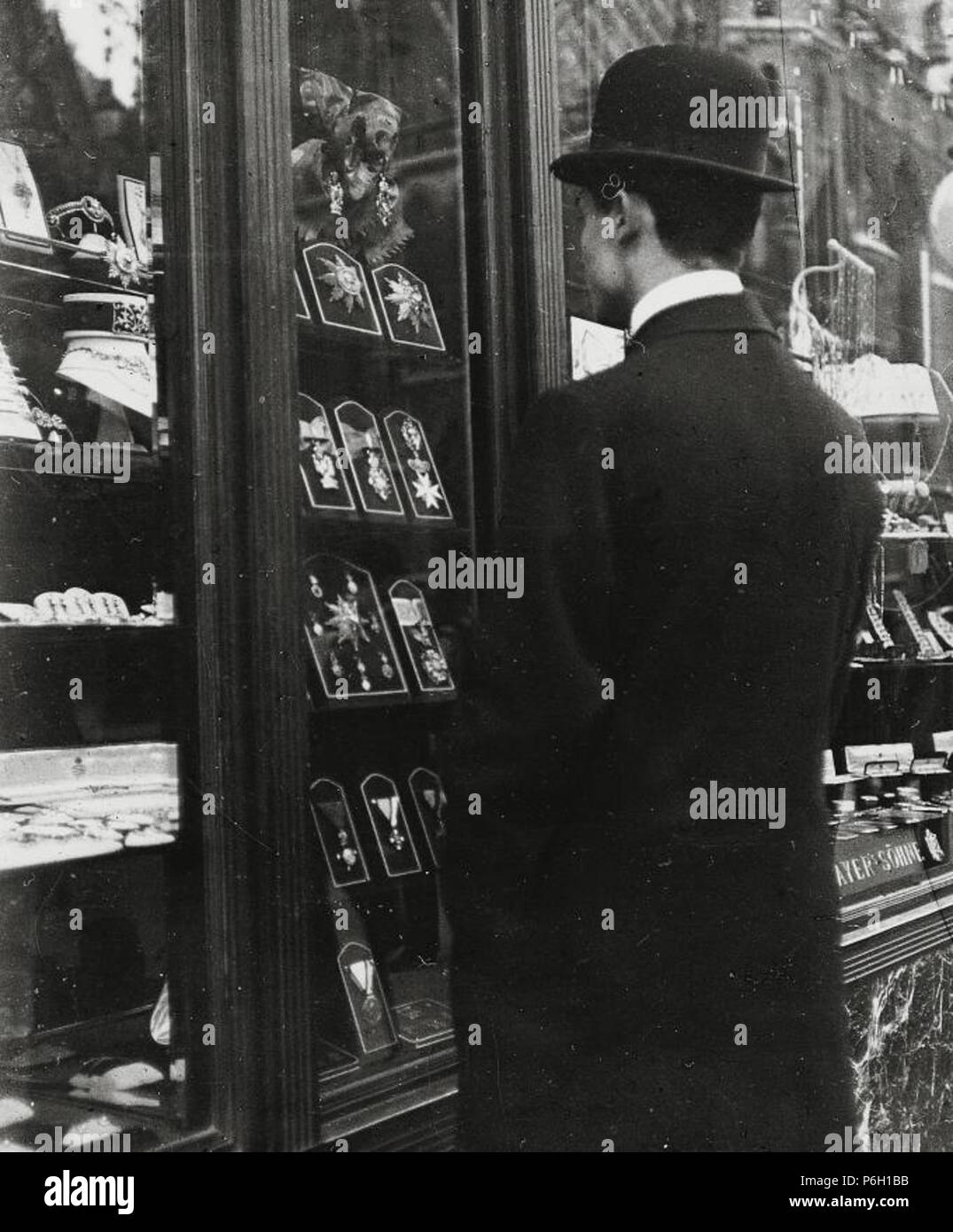 Mann vor dem Schaufenster der Fa. V. Mayer Söhne, k. u. k. Hofjuweliere (spezialisiert auf Orden und Ehrenzeichen), Stock-im-Eisen-Platz, Wien . tra il 1905 e il 1914 41 Emil Mayer 029 Foto Stock