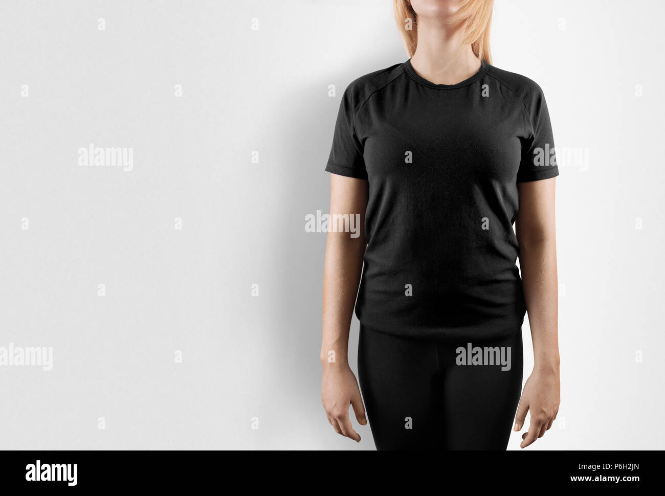 Blank black t-shirt design mockup. Donne stare vicino a wal in tshirt grigio chiaro anteriore modello mock up. Vuoto abbigliamento femminile uniforme modello di singoletto. Il sudore tee shirt abito semplice e superficie pronta per la stampa. Foto Stock