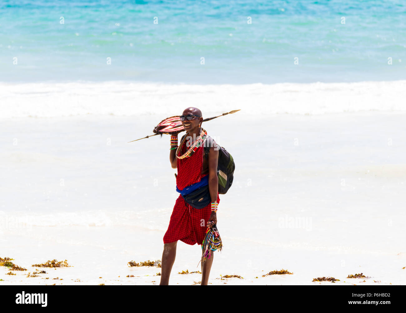 Diani Beach Mombasa, in Kenya - 10.30.2017: nero singolo maschio keniota indossando il tradizionale masai abbigliamento cercando di guadagnarsi da vivere con la vendita di souvenir in Foto Stock