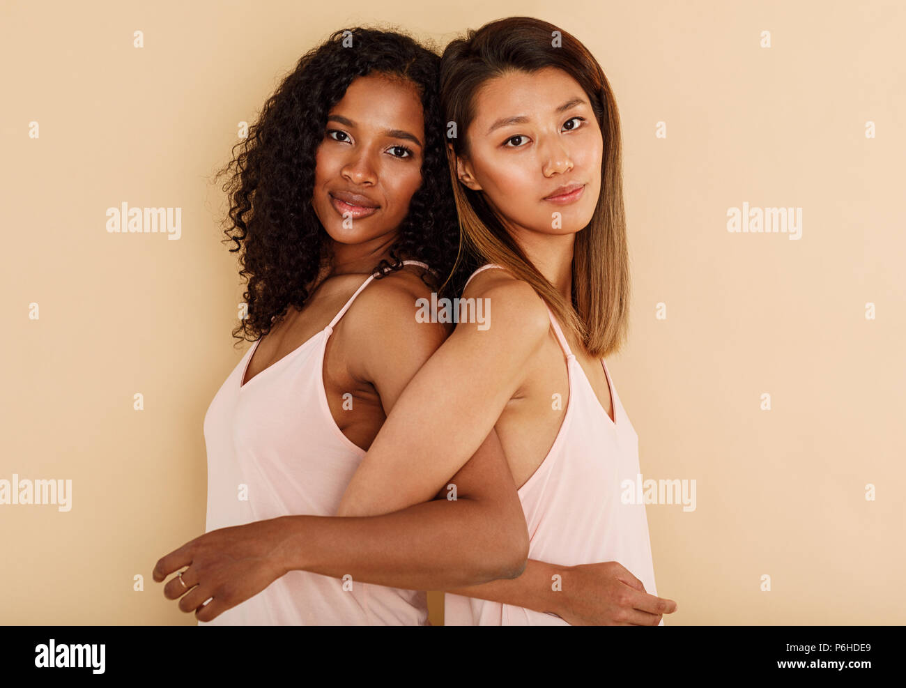 Due diverse donne in piedi di schiena in studio Foto Stock