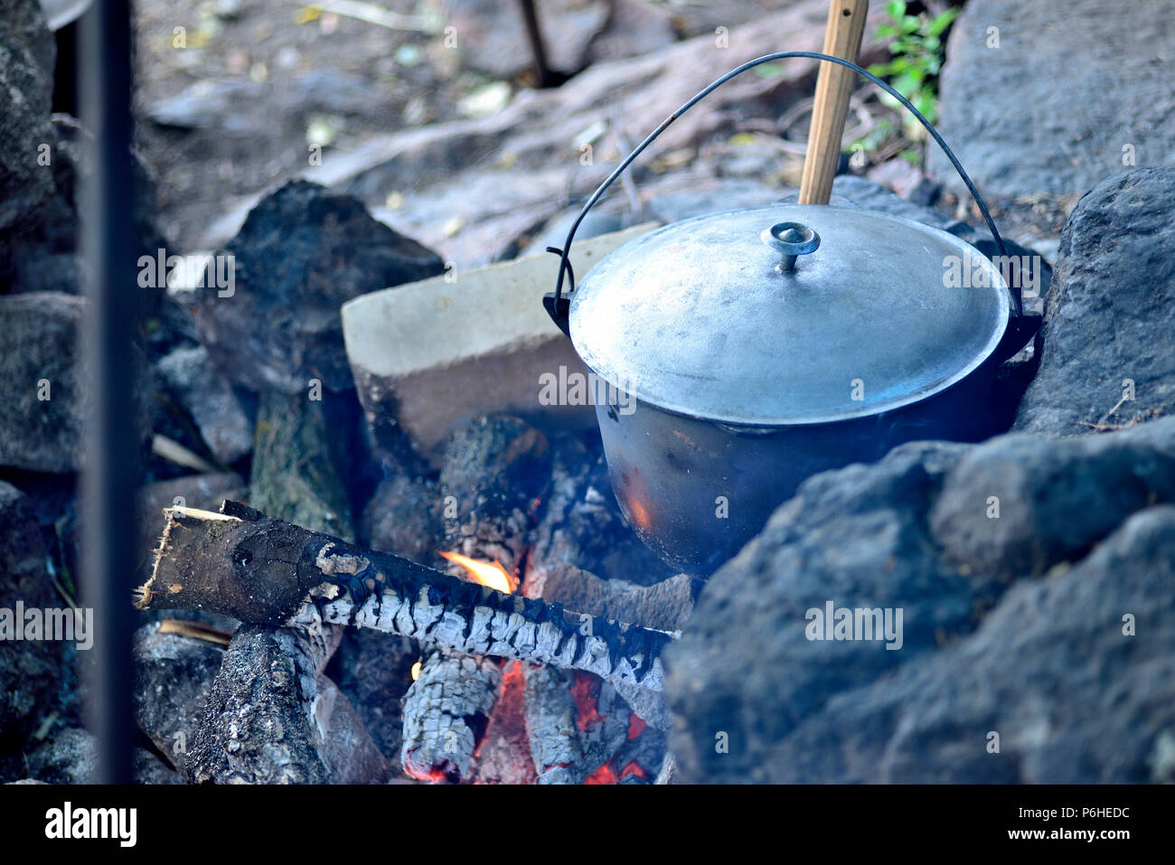 La cottura in un paiolo di rame su un fuoco aperto. Preparare il cibo al  gioco in un campeggio selvaggio. Per cucinare la cena in una pentola a  fuoco. per mangiare all'aperto