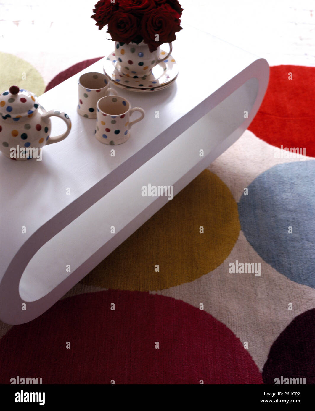 Close-up di spotted tazze e teiera su un bianco in stile anni cinquanta ovale tavolo da caffè Foto Stock