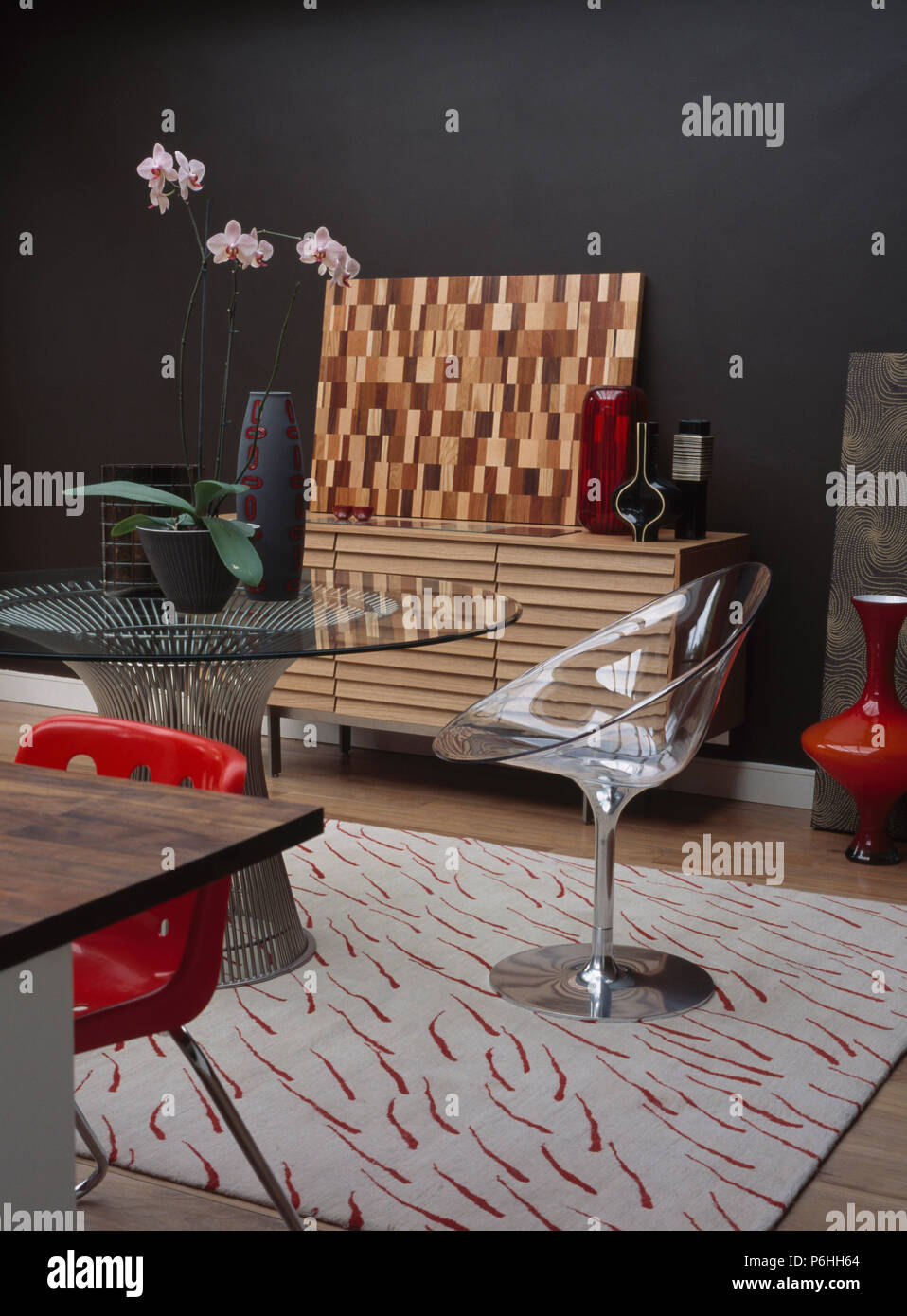 Piedistallo acrilico sedia e con ripiano in vetro metallico circolare tabella nel soggiorno moderno con motivi geometrici tappeto bianco Foto Stock