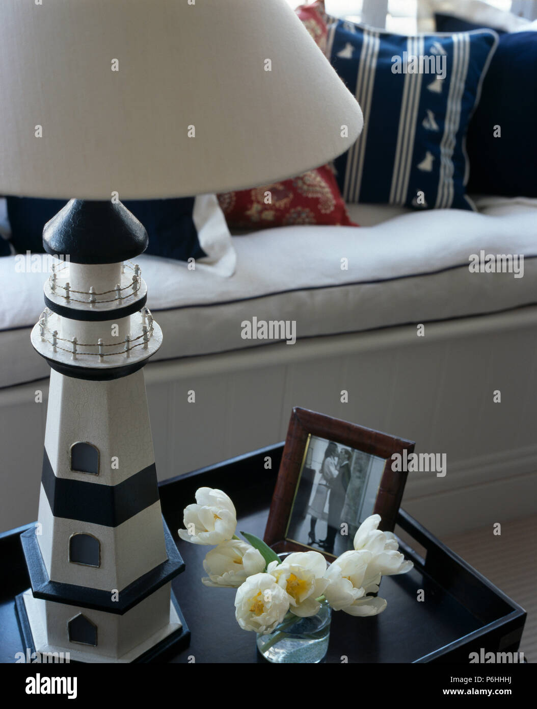 Close-up della lampada del faro sul piccolo tavolo con vaso di tulipani bianco e incorniciato fotografia Foto Stock
