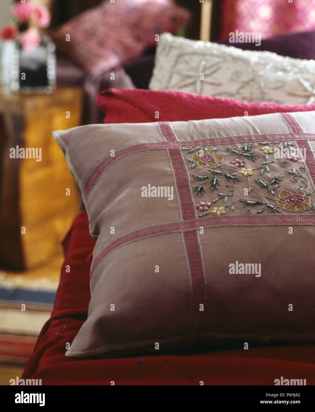 Close-up di rosa seta Cuscino ricamato rifinito con una rosa di nastro di velluto Foto Stock
