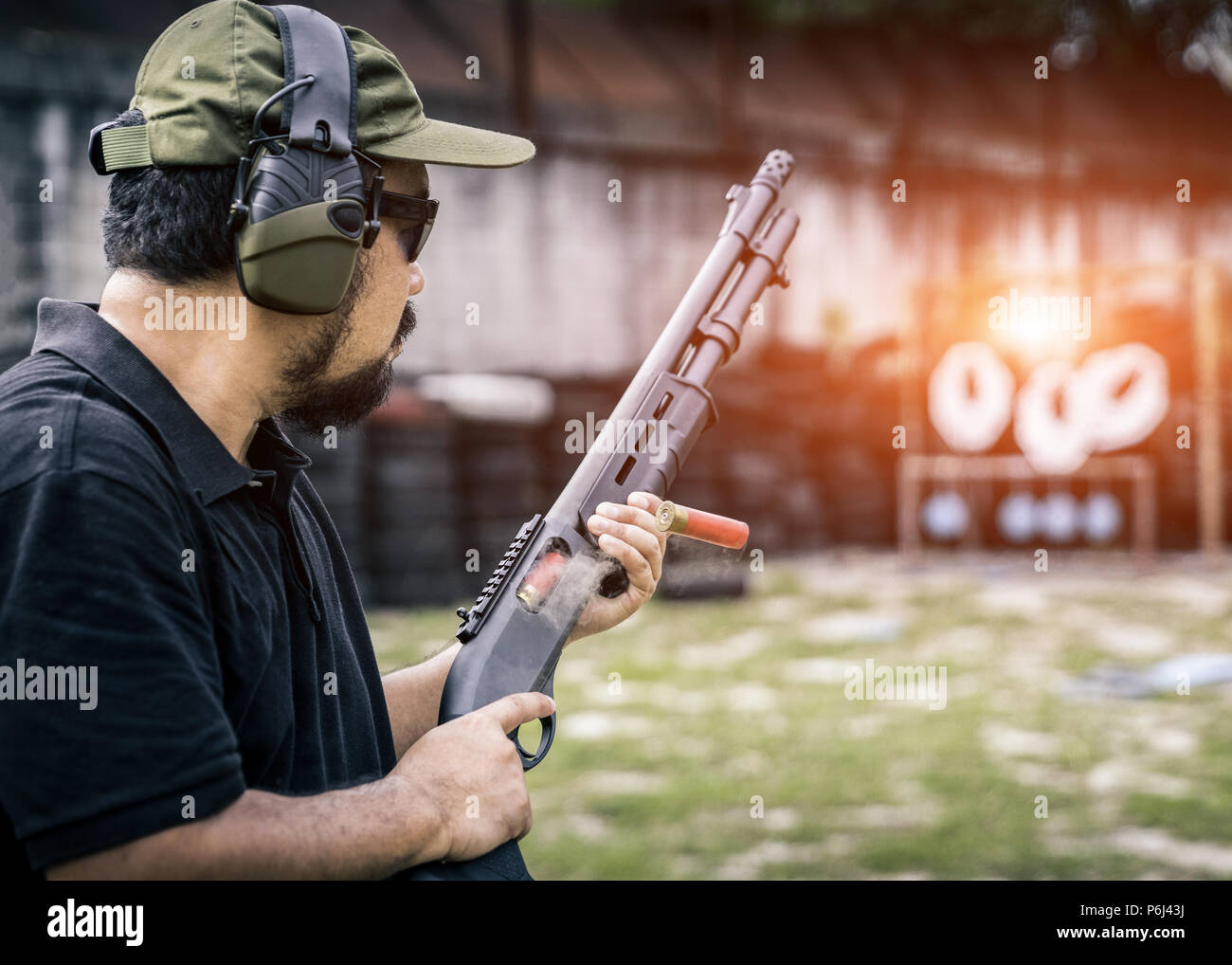 Vista di un uomo con un fucile da caccia ricaricare la cartuccia. Foto Stock