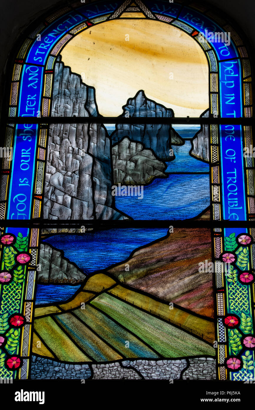 Gran Bretagna, Shetland, Fair Isle. Chiesa di Scozia Kirk, vetrate colorate. Dettaglio della finestra con la paesaggistica costa. Foto Stock