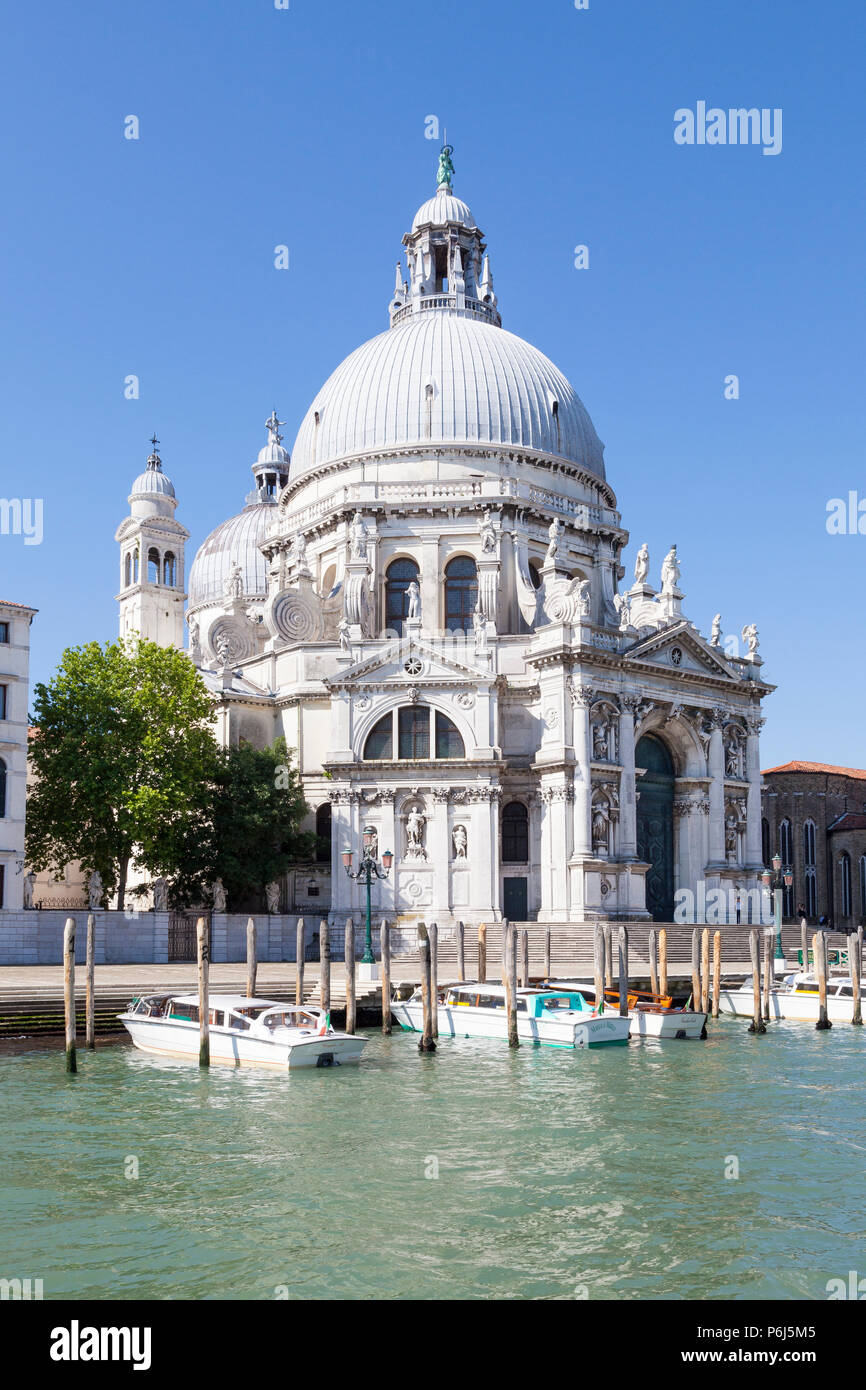 Basilica di Santa Maria della Salute, Grand Canal, Dorsoduro, Venezia, Veneto, Italia in mattina presto luce. La facciata esterna con ormeggiati i taxi d'acqua Foto Stock