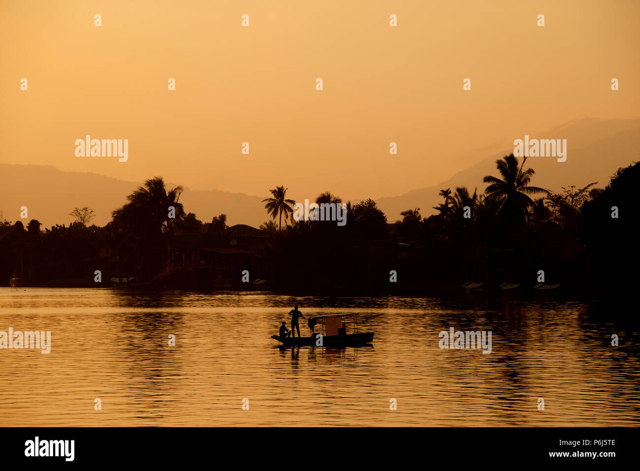 Piccola barca da pesca Attraversamento fiume Sarawak al tramonto Kuching Sarawak Malaysia Foto Stock