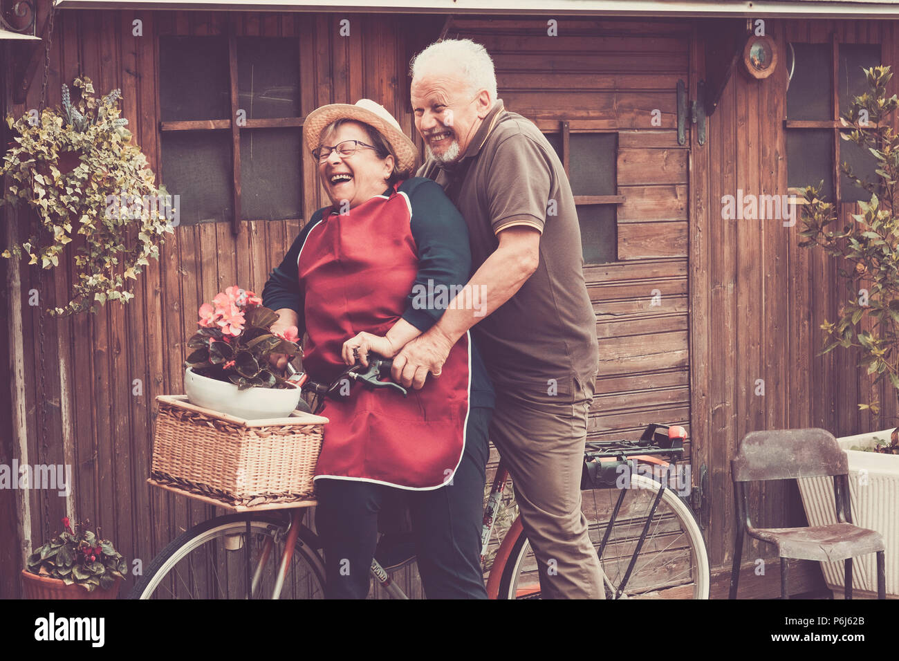Bella gente caucasica godere il tempo libero outdoor entrambi su un unico bike lauhing come un matto. insieme momenti divertenti a casa fuori. vintage e filtro colore Foto Stock