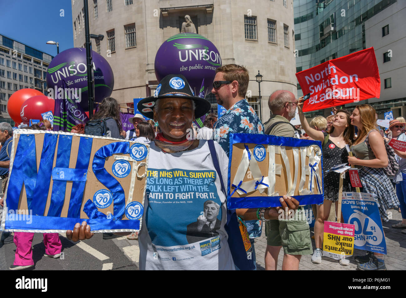 Giugno 30, 2018 - Londra, Regno Unito. Il 30 giugno 2018. Una donna detiene il poster "NHS 4MAI' come lei attende con migliaia di attivisti di NHS al di fuori della BBC a marzo a Londra per un rally vicino a Downing St per celebrare i 70 anni del NHS, e per sostenere i suoi collaboratori dedicati nel chiedere una proprietà pubblica che NHS è libera per tutti con un adeguato finanziamento e la corretta assegnazione di personale e fornendo un mondo di servizi di classe per ogni comunità. La protesta, organizzato dall'assemblea del popolo, campagne di salute insieme, Trades Union Congress, Unison, unite, GMB, la British Medical Association, Royal College of Nursing Roya Foto Stock