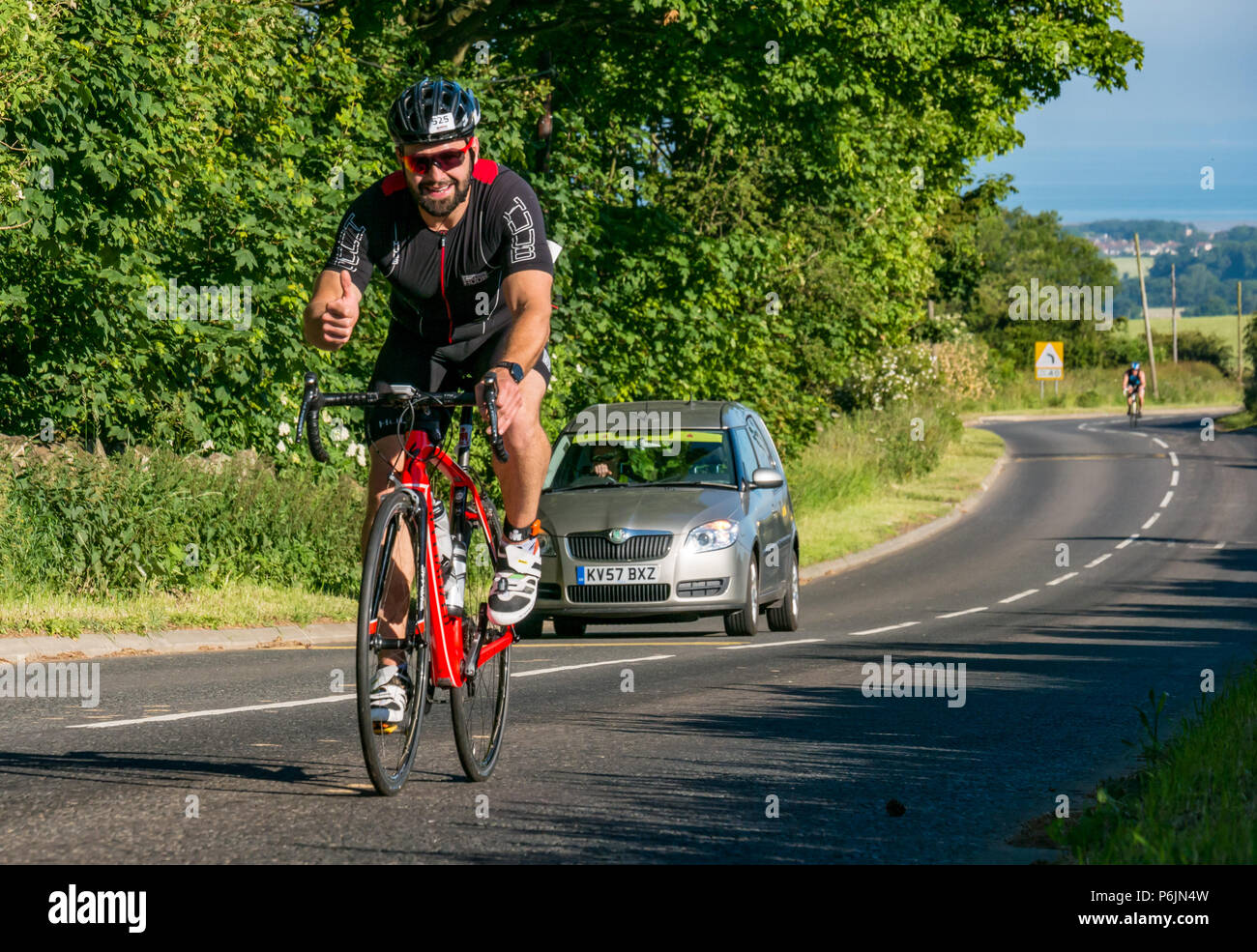 Byres Hill, East Lothian, Scozia, Regno Unito, 1 luglio 2018. Edinburgh IRONMAN 70.3, Byres Hill, East Lothian, Scozia, Regno Unito, 1 luglio 2018. Ciclismo parte dell'evento sportivo endurance. I concorrenti si lanciano in bicicletta in salita passando da Byres Hill su un percorso ciclistico di 56 km dopo aver completato la nuotata prima di una corsa di 26.1 km come parte dell'evento Triathlon Foto Stock