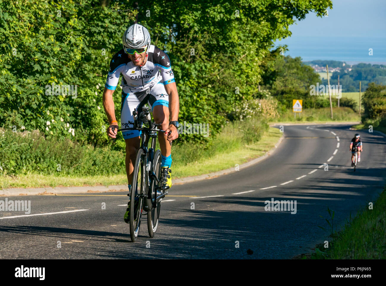 Byres Hill, East Lothian, Scozia, Regno Unito, 1 luglio 2018. Edinburgh IRONMAN 70.3, Byres Hill, East Lothian, Scozia, Regno Unito, 1 luglio 2018. Ciclismo parte dell'evento sportivo endurance. I concorrenti si lanciano in bicicletta in salita passando da Byres Hill su un percorso ciclistico di 56 km dopo aver completato la nuotata prima di una corsa di 26.1 km come parte dell'evento Triathlon Foto Stock