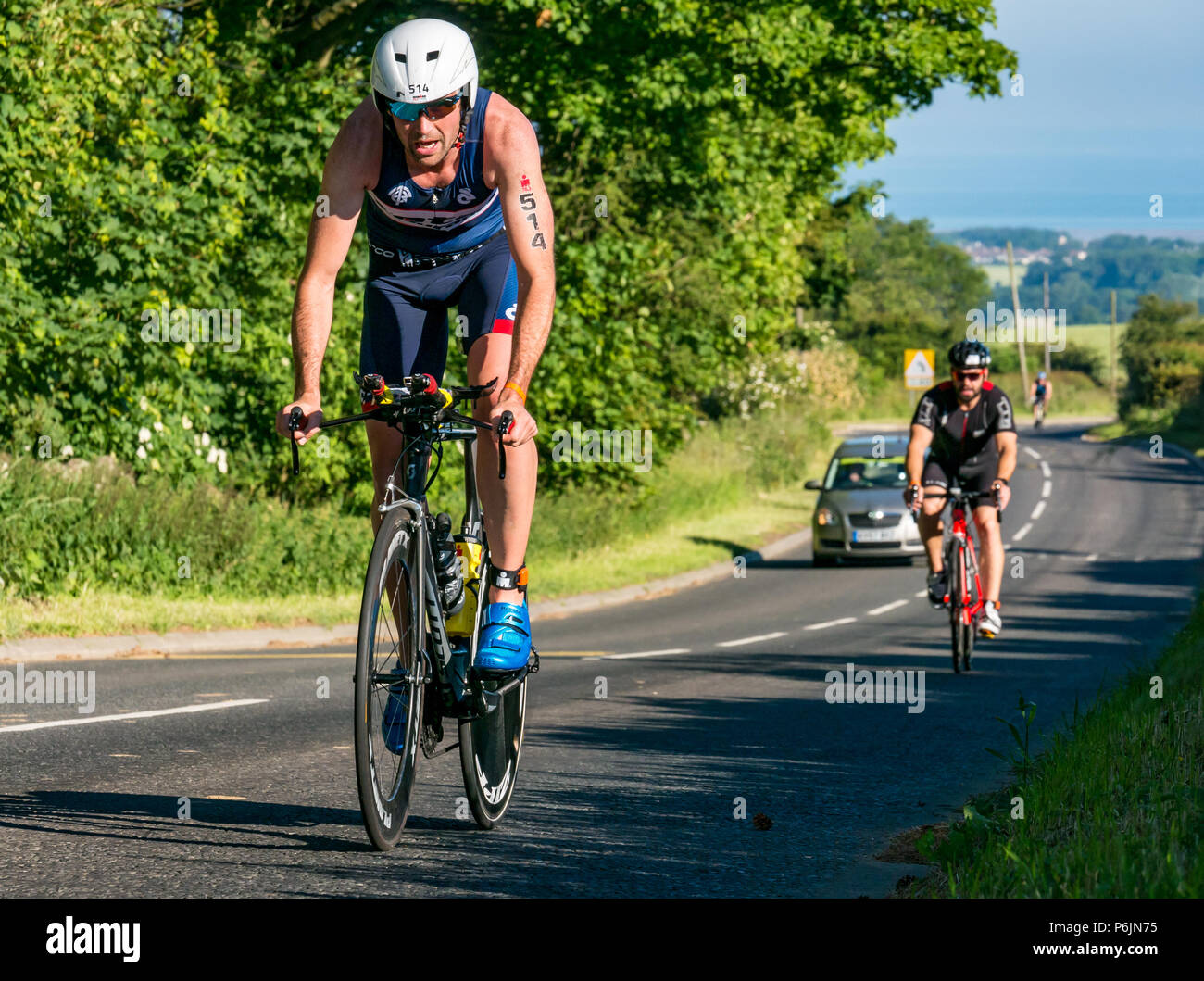 Byres Hill, East Lothian, Scozia, Regno Unito, 1 luglio 2018. Edinburgh IRONMAN 70.3, Byres Hill, East Lothian, Scozia, Regno Unito, 1 luglio 2018. Ciclismo parte dell'evento sportivo endurance. I concorrenti si lanciano in bicicletta in salita passando da Byres Hill su un percorso ciclistico di 56 km dopo aver completato la nuotata prima di una corsa di 26.1 km come parte dell'evento Triathlon Foto Stock