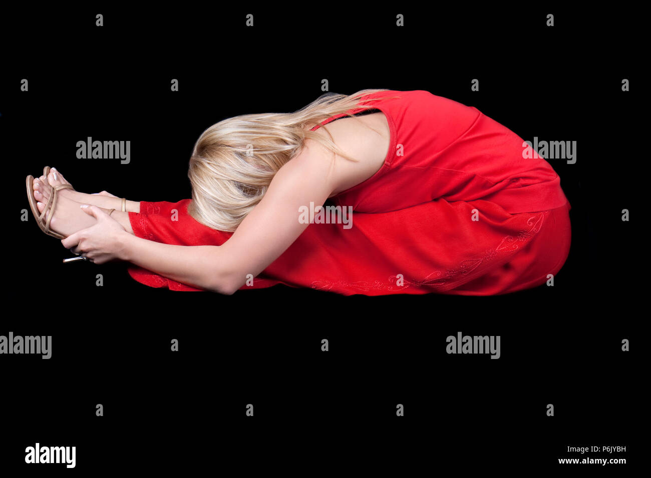 Business donna facendo joga a pausa pranzo , isolato su nero Foto Stock