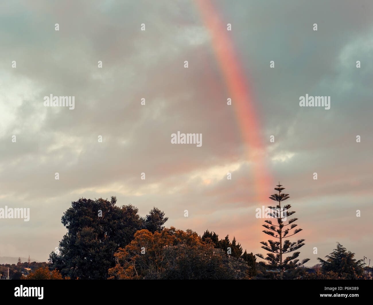 Raibow attraverso un cielo nuvoloso al tramonto Foto Stock