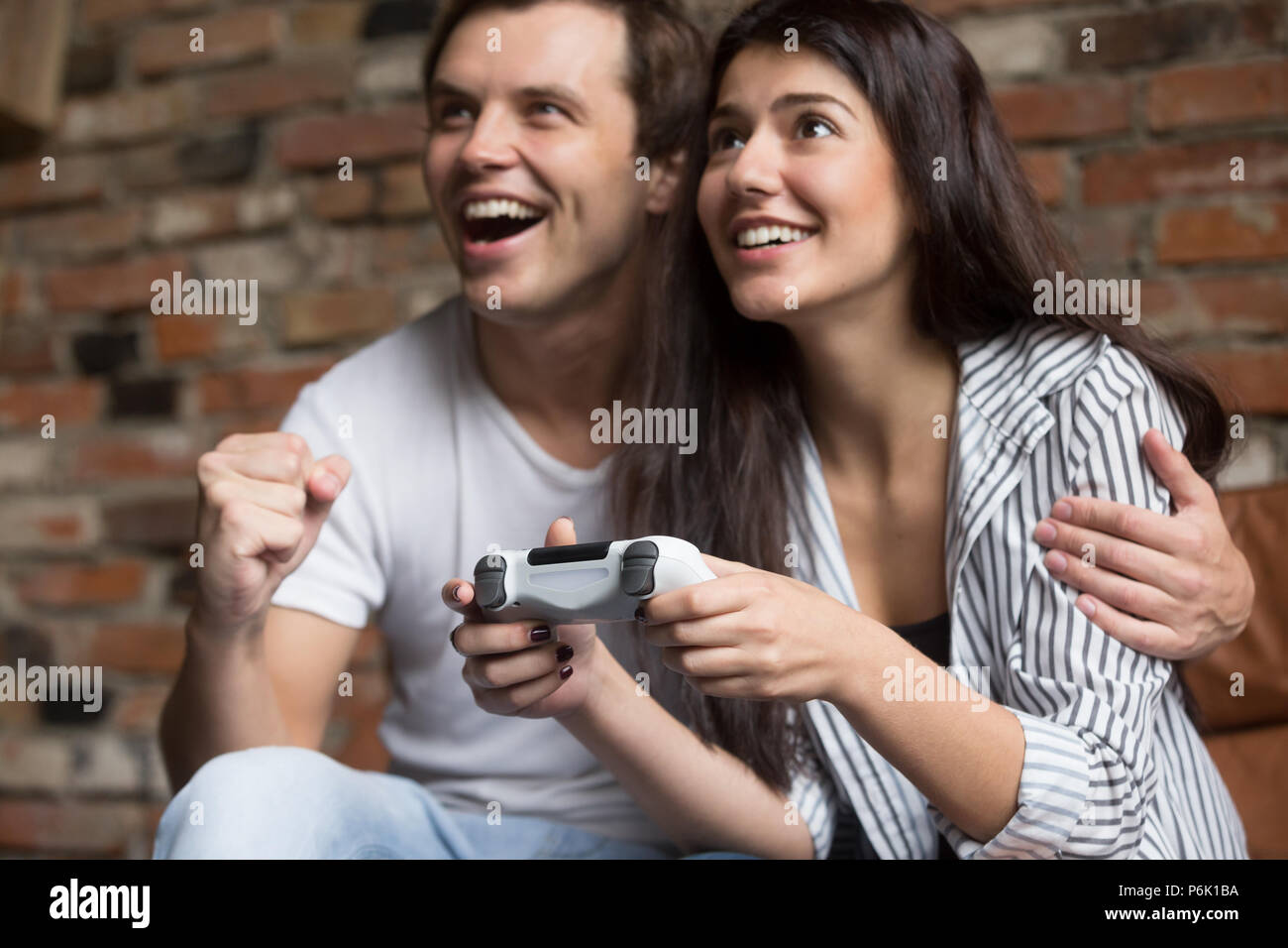 Eccitato giovane la riproduzione di videogiochi del computer insieme Foto Stock