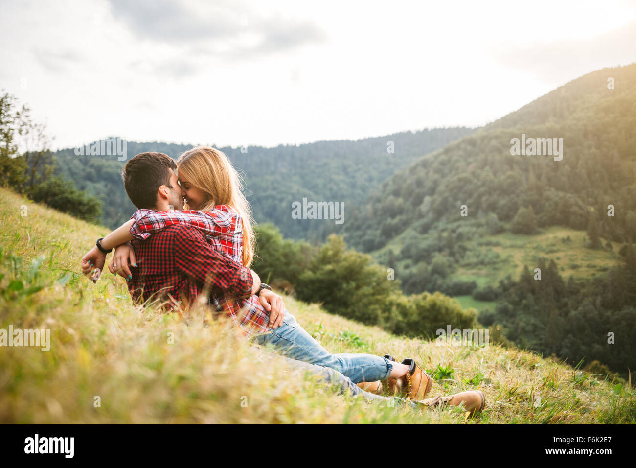 Elegante e moderno giovane sdraiati sull'erba e baciare. Foto Stock