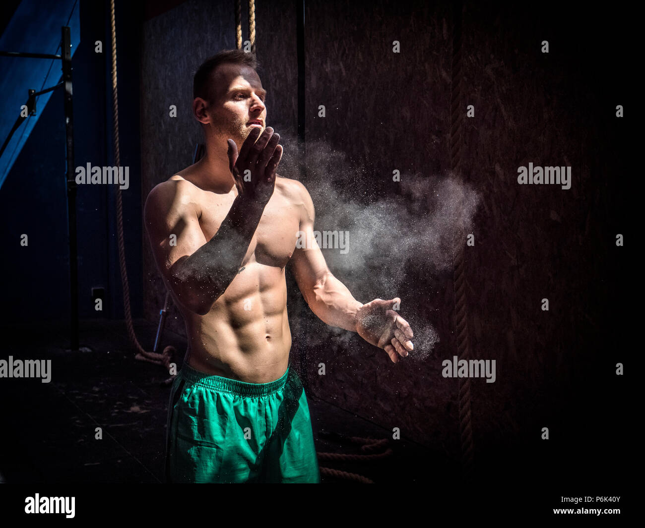 Shirtless uomo usando il gesso o polvere di magnesio in palestra, battendo  le mani e la creazione di cloud Foto stock - Alamy