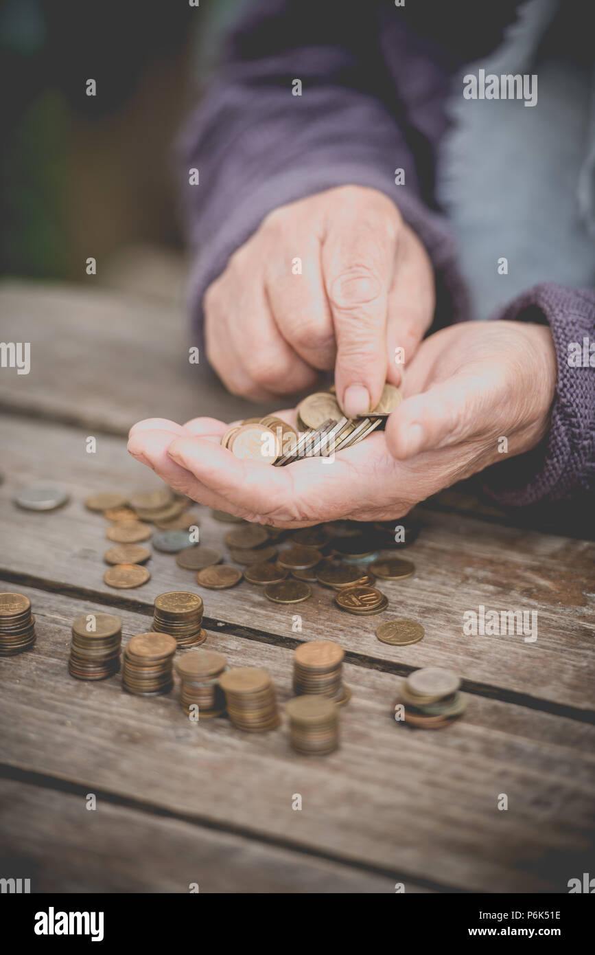 Soldi, monete, ritirato la nonna e la nozione di un salario di sussistenza - la vecchia donna purtroppo trova poco denaro Foto Stock