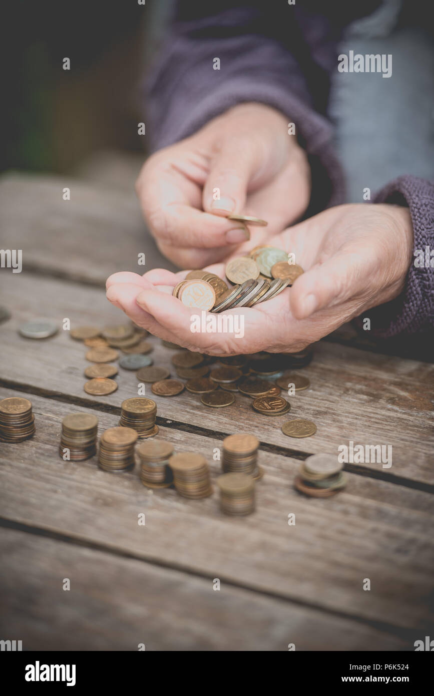 Soldi, monete, ritirato la nonna e la nozione di un salario di sussistenza - la vecchia donna purtroppo trova poco denaro Foto Stock