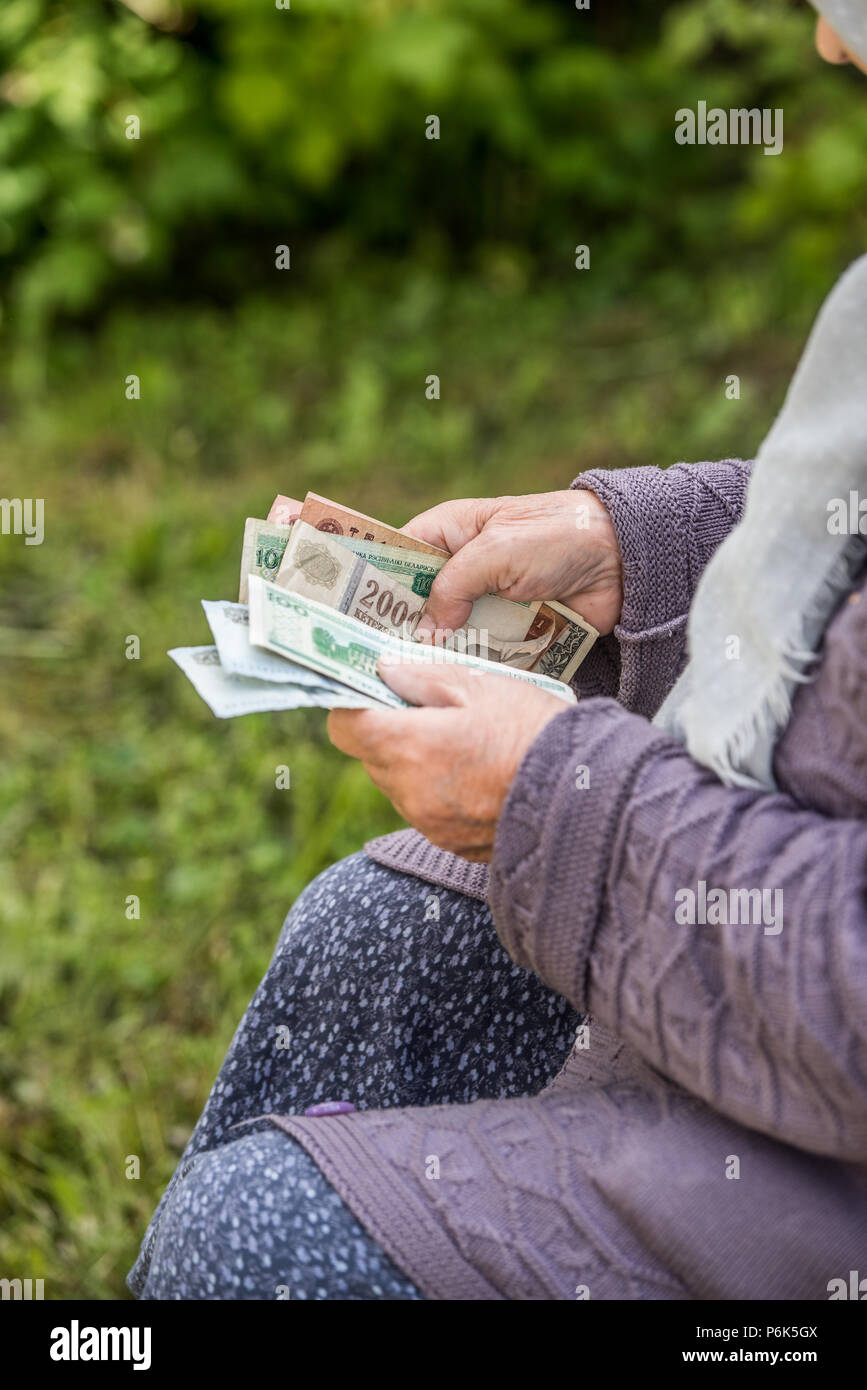Il vecchio donna considera le banconote - mani e denaro close up Foto Stock