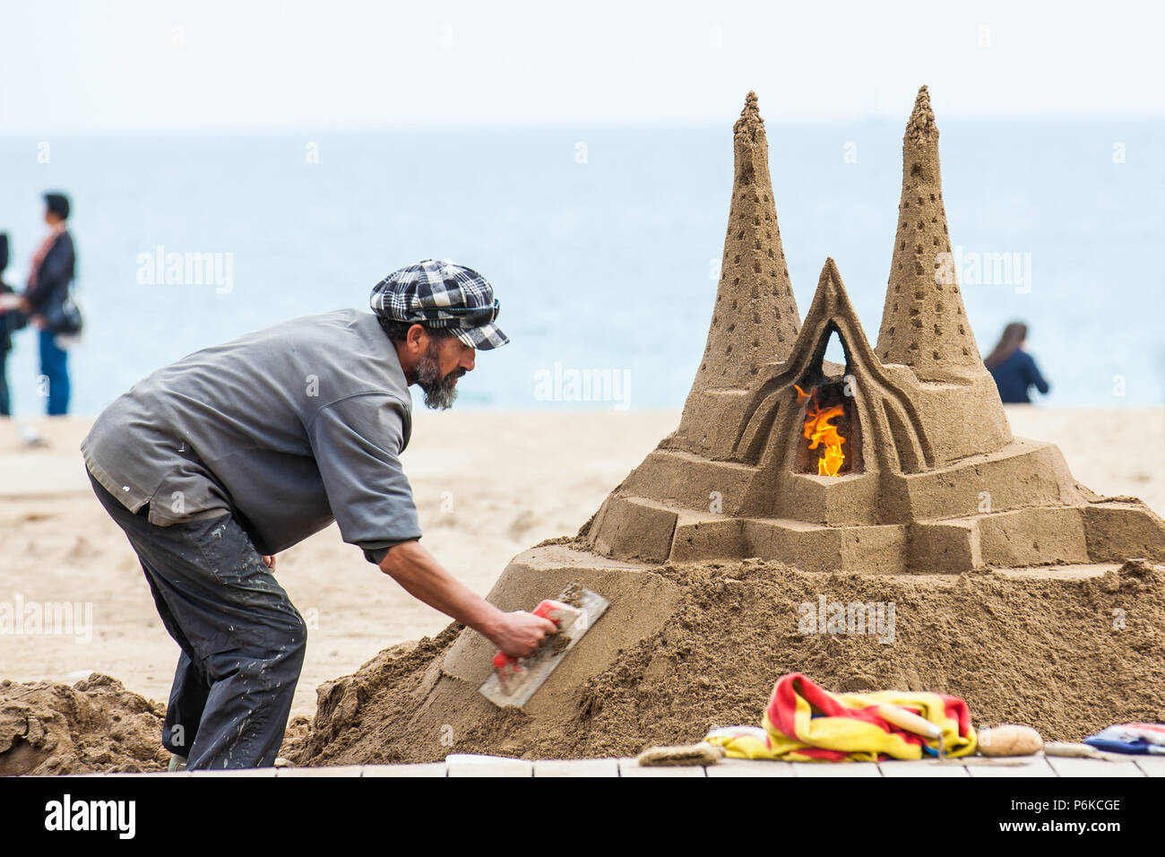 Scultore di sabbia a lavorare presso la spiaggia di Barceloneta a Barcellona Spagna Foto Stock