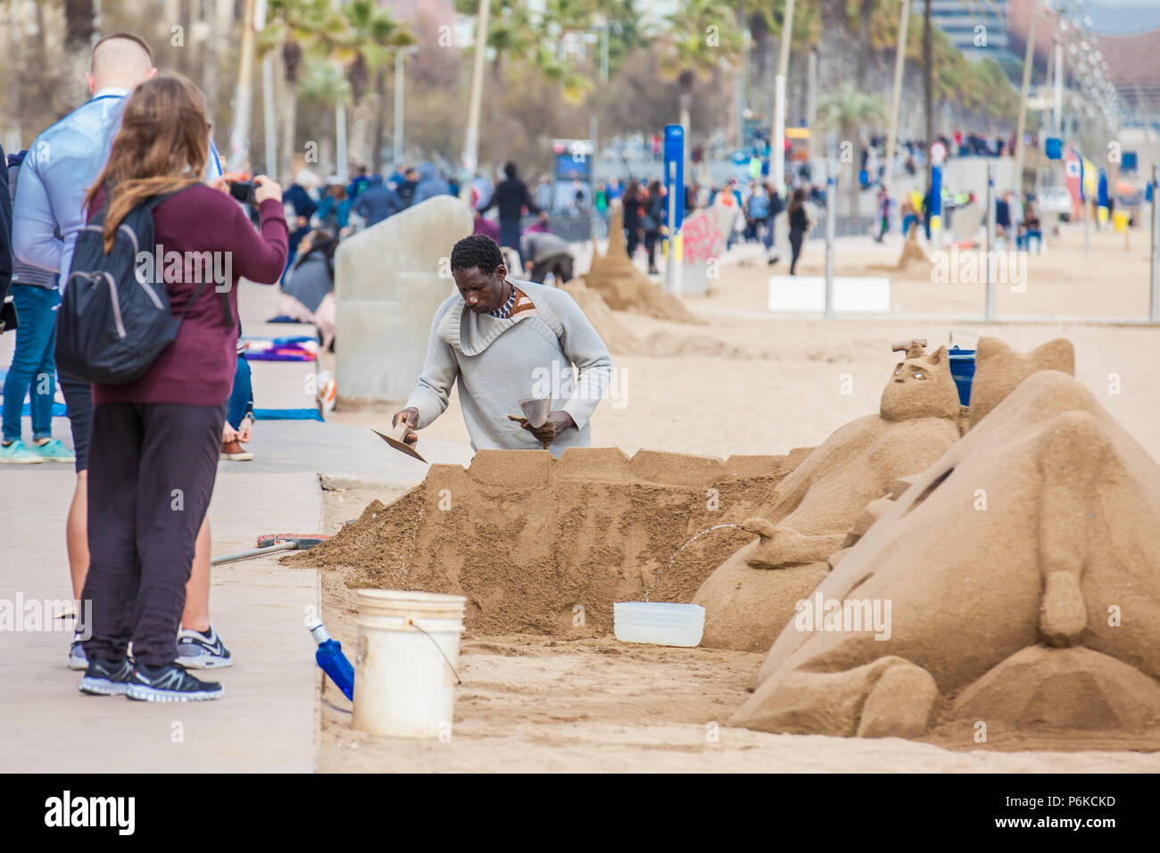 Scultore di sabbia a lavorare presso la spiaggia di Barceloneta a Barcellona Spagna Foto Stock