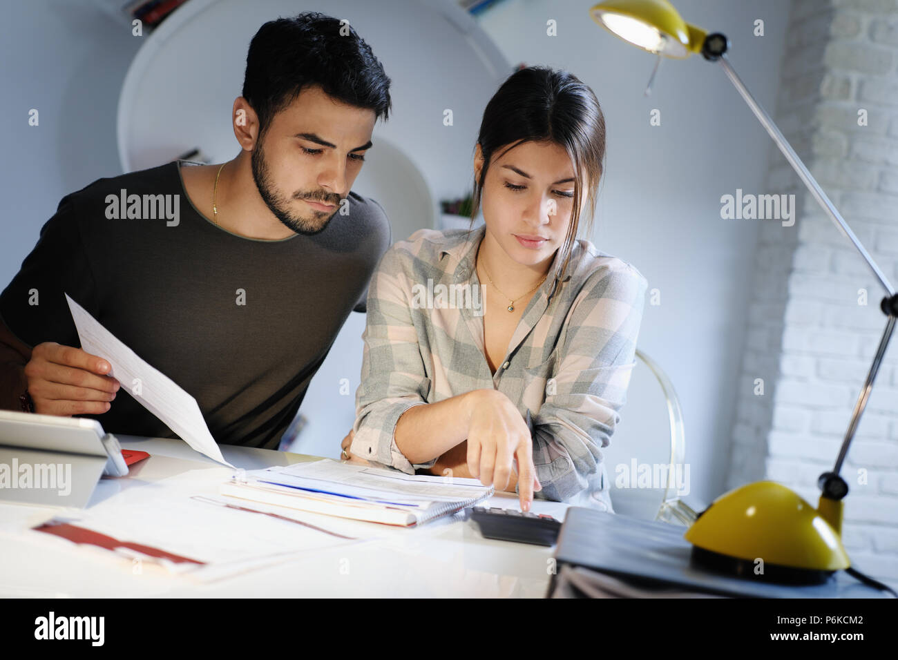 L uomo e la donna preoccupati per le tasse e bilancio familiare Foto Stock
