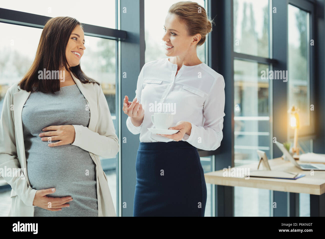 Curioso boss fare domande mentre si parla di un dipendente in stato di gravidanza Foto Stock