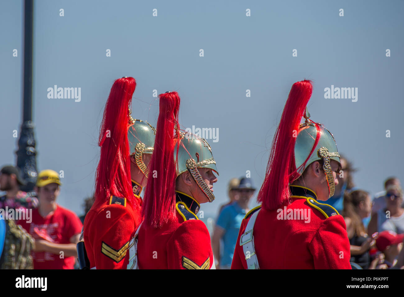 Forze armate giorno 2018 a Llandudno. Marciando saldature in divisa rossa. Una giornata molto calda. soldati sudorazione in uniforme. Foto Stock