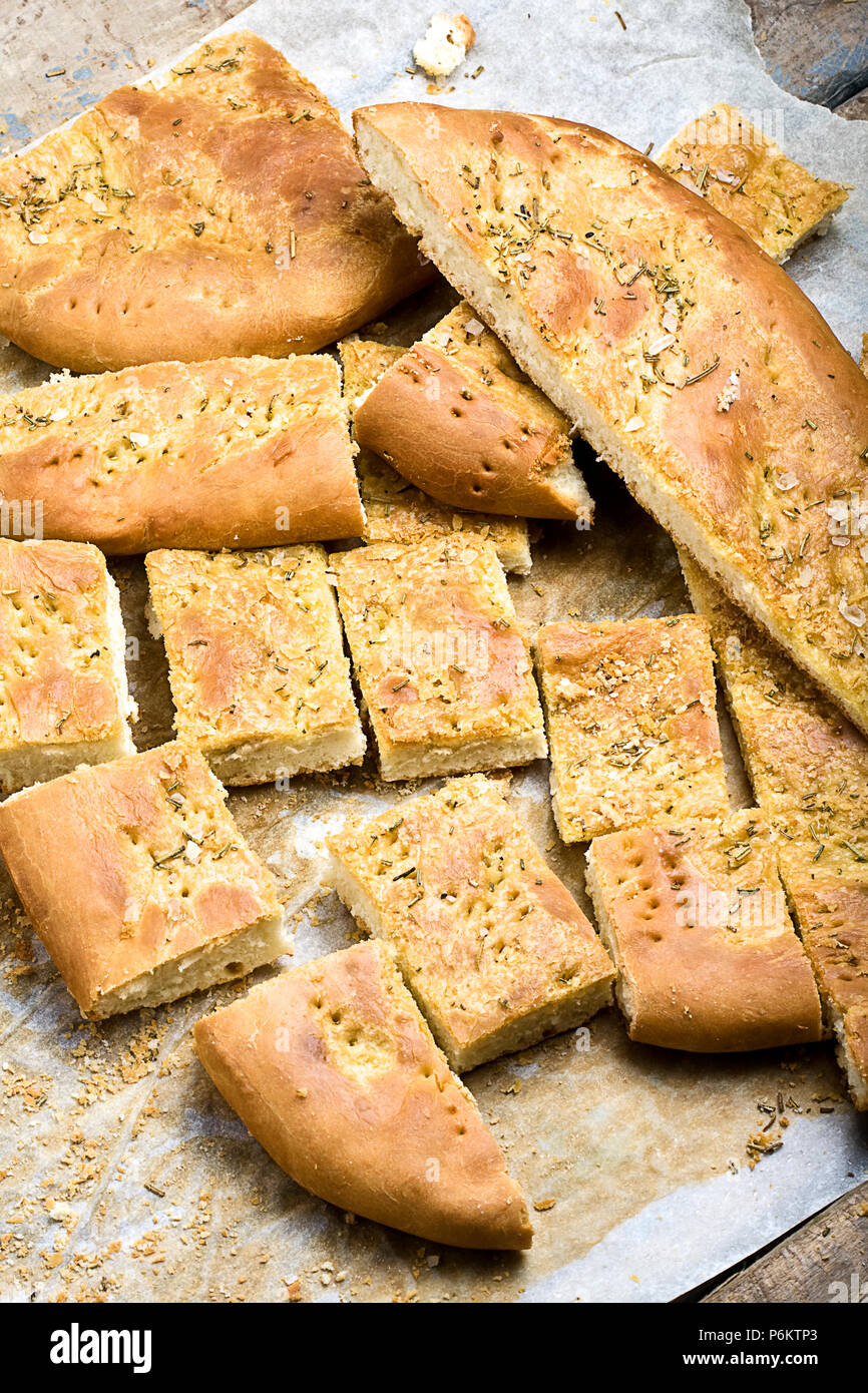 Fette di pane foccacia con rosmarino e olio di oliva fuori del forno su legno tavolo rustico Foto Stock