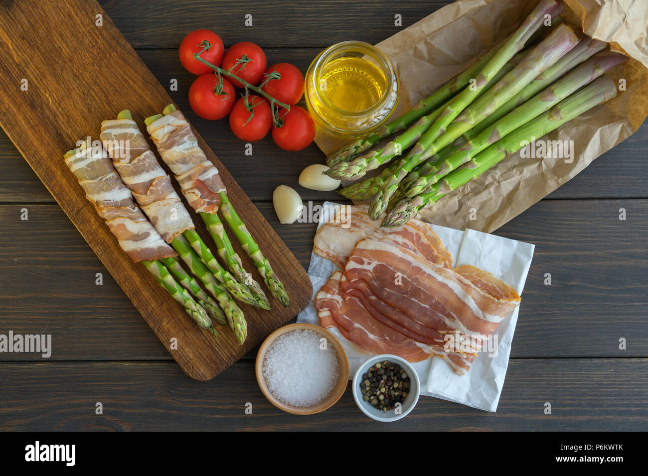 Organici freschi Asparagi avvolti nel prosciutto di Parma su un tagliere Foto Stock