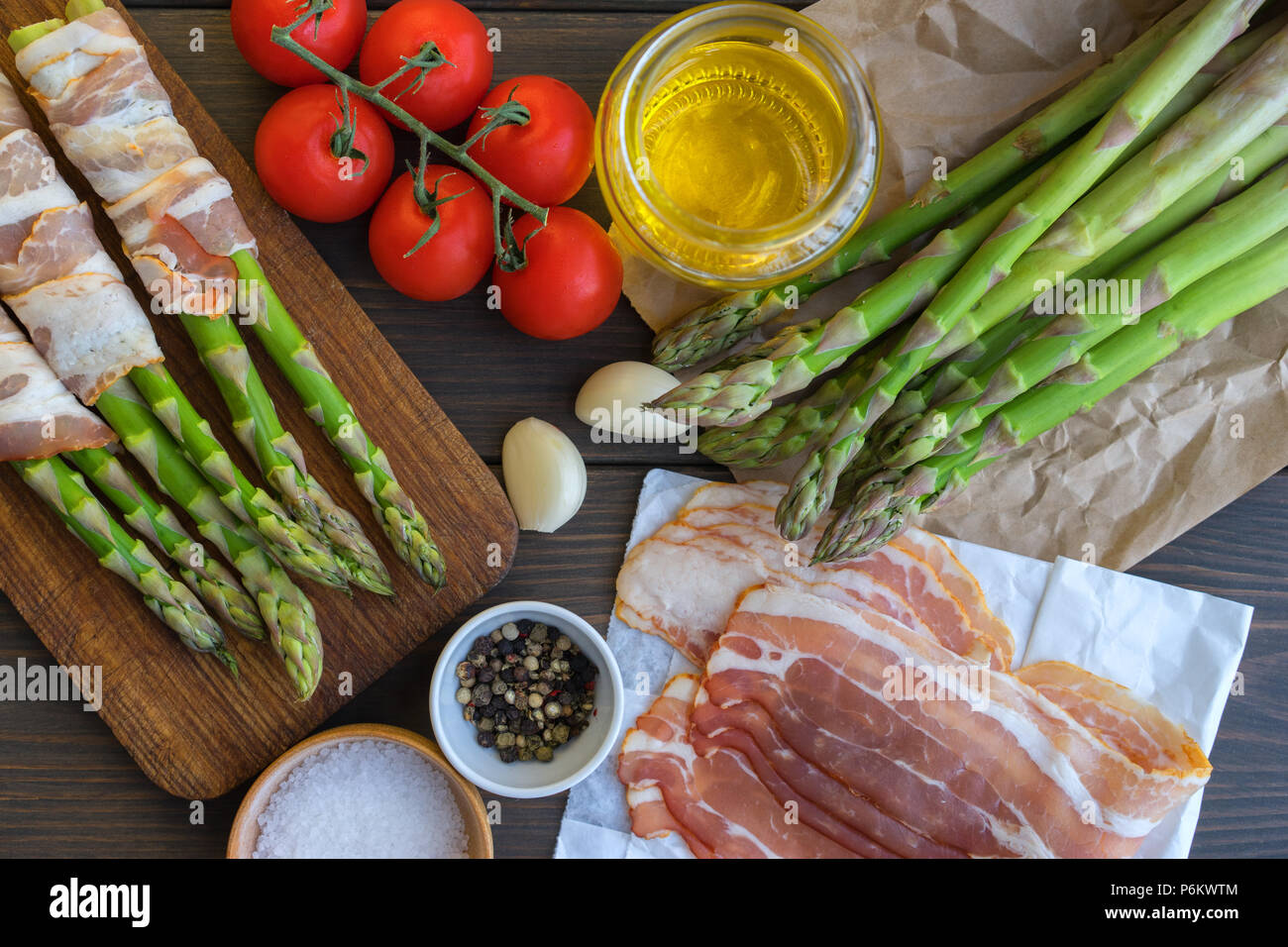 Organici freschi Asparagi avvolti nel prosciutto di Parma su un tagliere Foto Stock