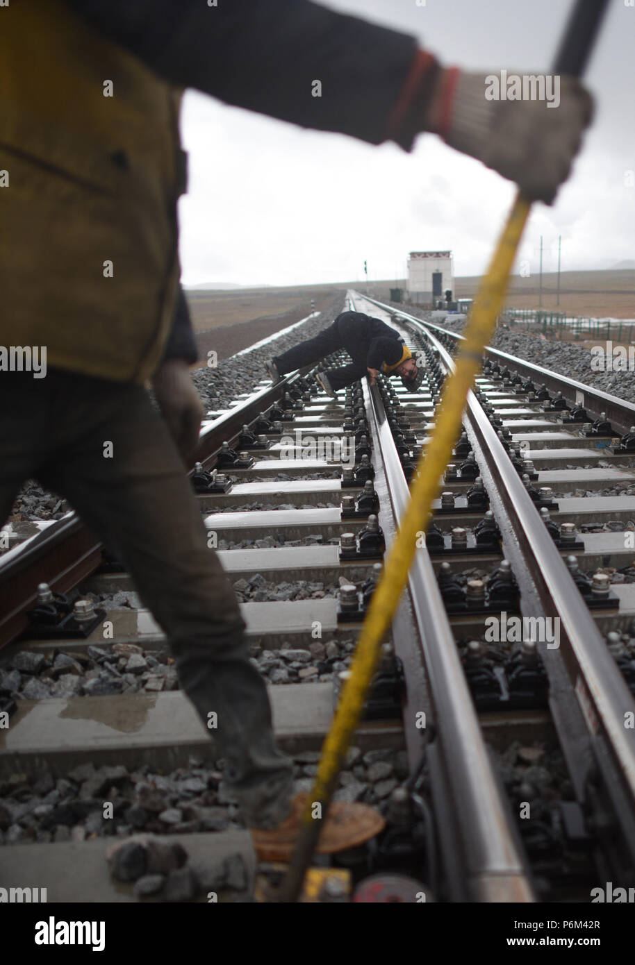 Golmud, la Cina della Provincia di Qinghai. Il 30 giugno, 2018. Un lavoratore di verificare lo stato dei binari nei pressi della stazione di Tanggula della ferrovia Qinghai-Tibet, a nord-ovest della Cina di Provincia di Qinghai, 30 giugno 2018. Lavoratori di manutenzione stick per i loro posti ogni giorno per garantire il funzionamento della ferrovia Qinghai-Tibet presso la stazione di Tanggula con un altitudine di 5,072 metri sopra il livello del mare. Il 1,956 chilometri di ferrovia, che ha iniziato il servizio nel luglio 2006, è la più alta del mondo altopiano di collegamento ferroviario Xining in Qinghai e Lhasa nella regione autonoma del Tibet. Credito: Zhang Hongxiang/Xinhua/Alamy Live News Foto Stock