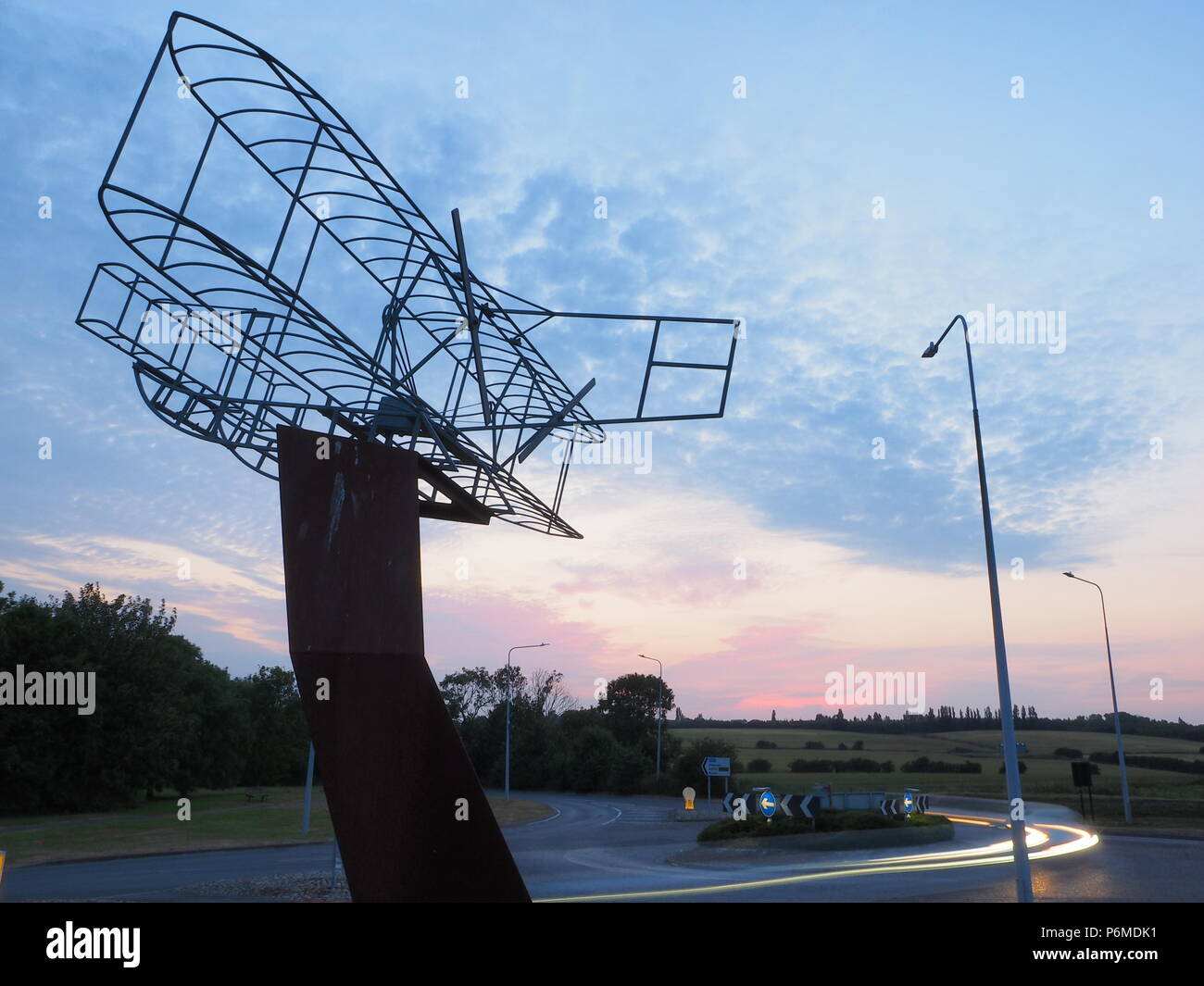 Eastchurch, UK. 1 Luglio, 2018. Regno Unito Meteo: il tramonto dietro la bi-piano scultura in Eastchurch, Kent. Eastchurch villaggio sull'Isle of Sheppey celebrato cento anni di storia dell'aviazione nel luglio del 2009, che la scultura è stata installata per commemorare i. Il primo volo controllato da un pilota britannico sul suolo britannico ha avuto luogo all'estremità orientale dell'isola di Sheppey, che è conosciuto come il luogo di nascita di aviazione britannica. Credito: James Bell/Alamy Live News Foto Stock