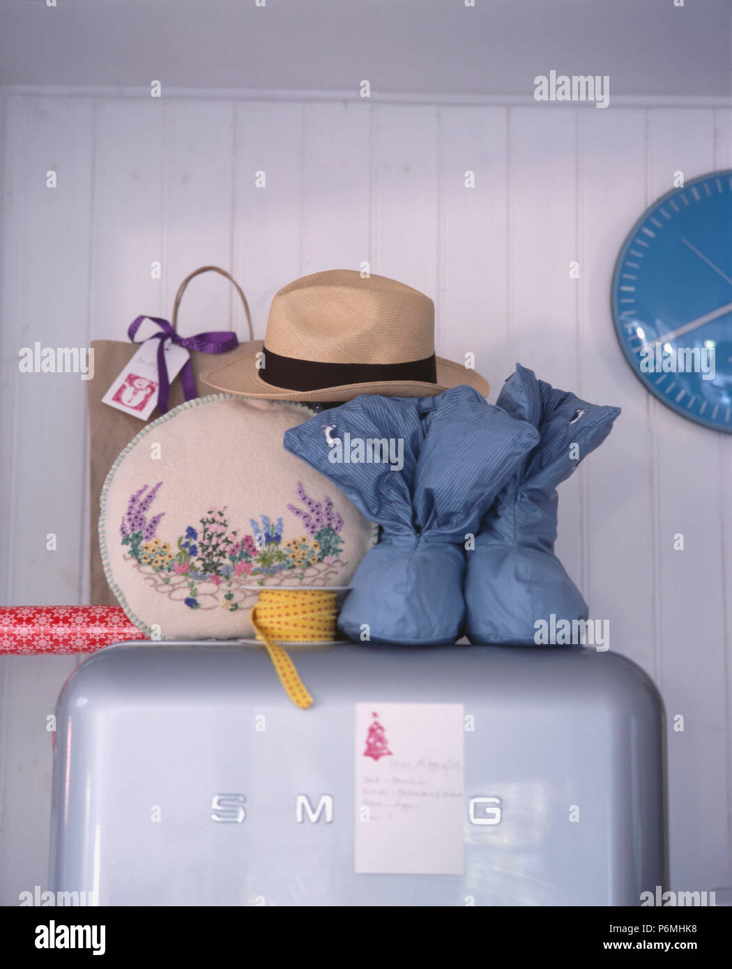Close-up di ricamato degli anni quaranta tea-cosy e boot blu-pantofole sulla sommità della Smeg frigorifero in cucina retrò Foto Stock