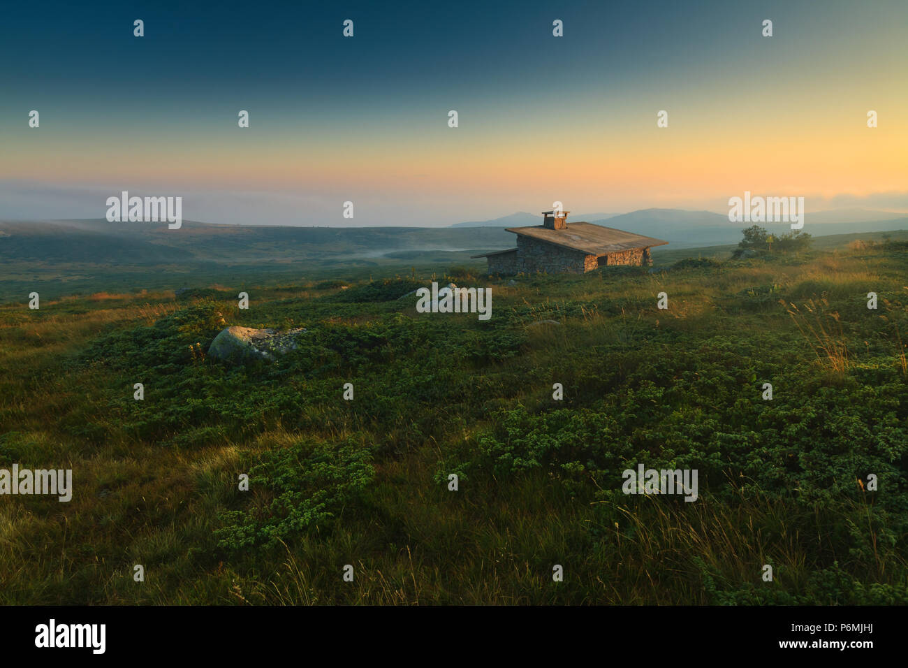 Bella montagna alpina verticale con cielo drammatico e pietra vecchia cabina. Altopiano di Vitosha vicino a Sofia, Bulgaria. Foto Stock