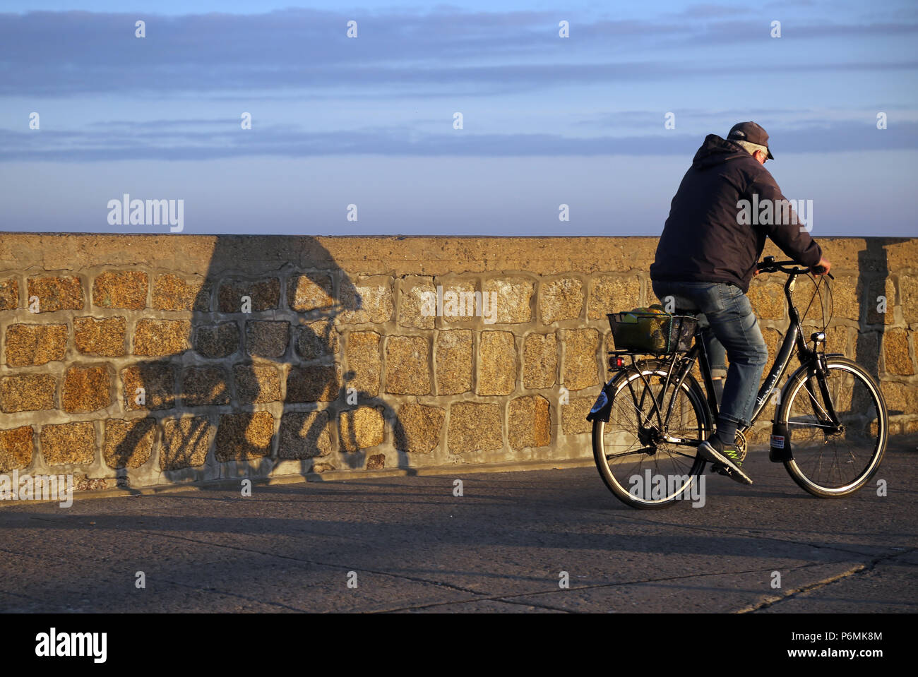 Warnemuende, ciclista getta un ombra contro una parete Foto Stock