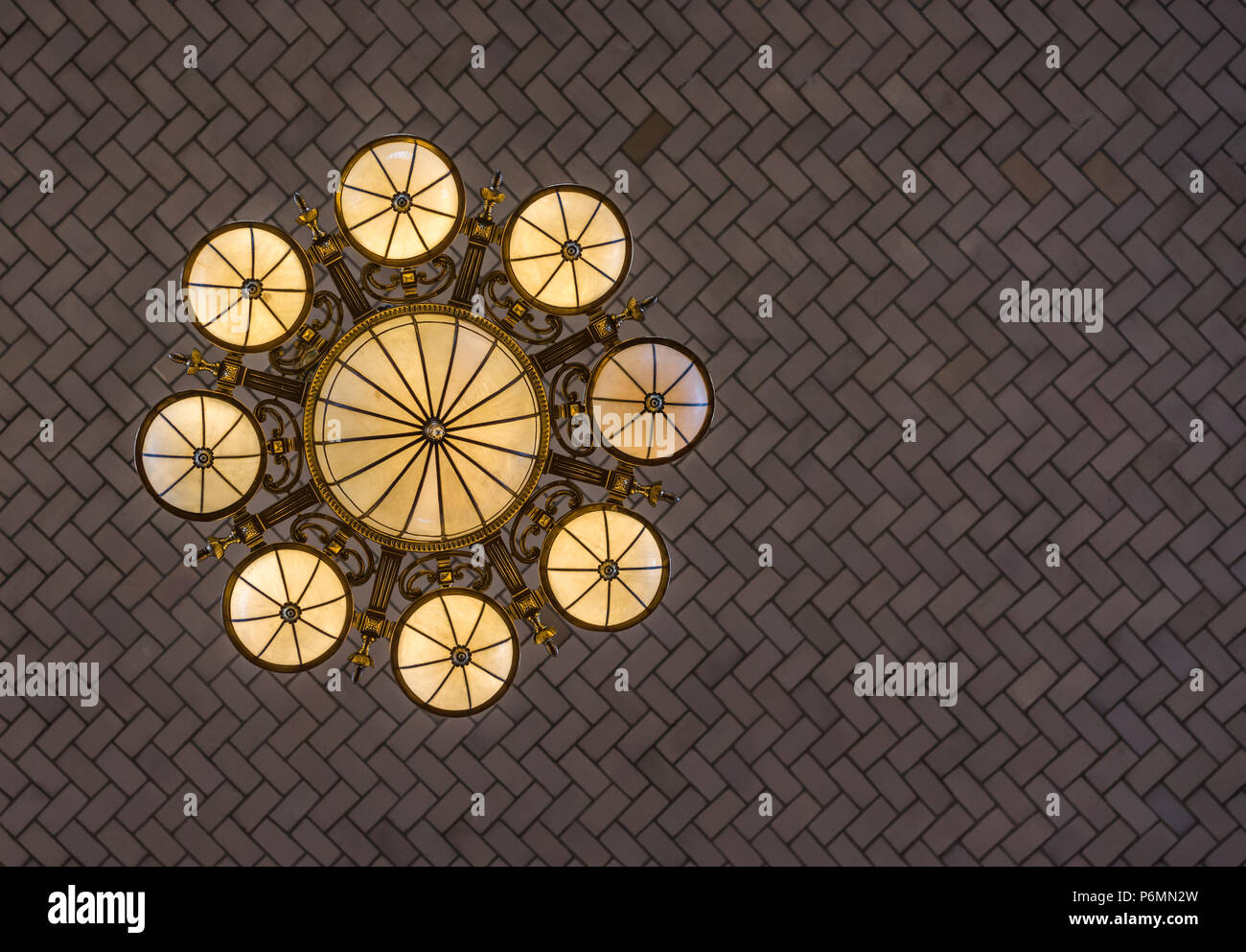 Bellissima lampada ornati pende da una stile herrinbone acrhed soffitto nell'area ricevimento su Ellis Island, off Manhattan, New York City ornato lampada h Foto Stock