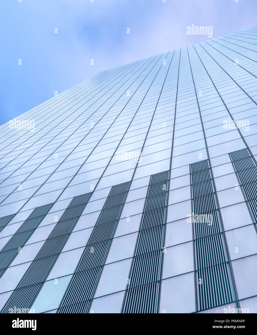 Guardando verso l'alto un vetro rivestito skyscaper contro un cielo blu a Manhattan, New York City Foto Stock