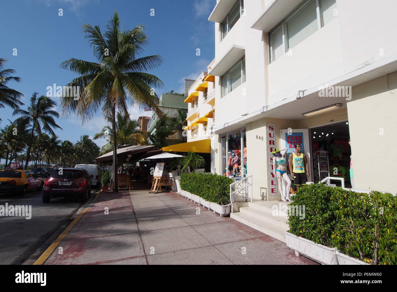 Scena di strada di vetrine, sidewalk café, edifici in stile liberty e palme sulla Ocean Drive a Miami Beach, Florida, Stati Uniti. Foto Stock