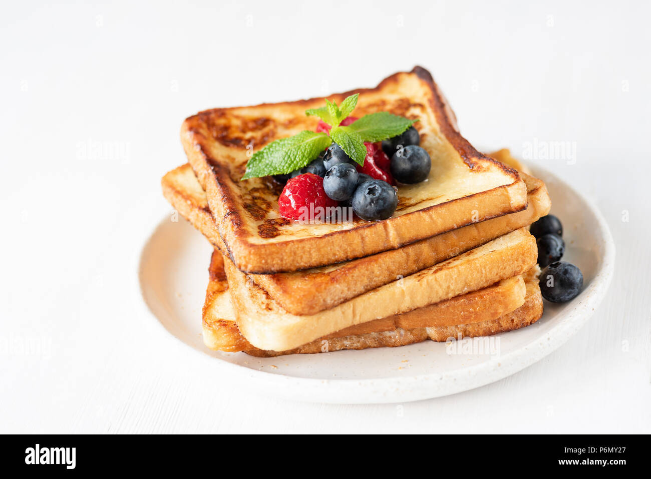 Toast alla francese con frutti di bosco isolato su bianco. Vista ingrandita, il fuoco selettivo Foto Stock