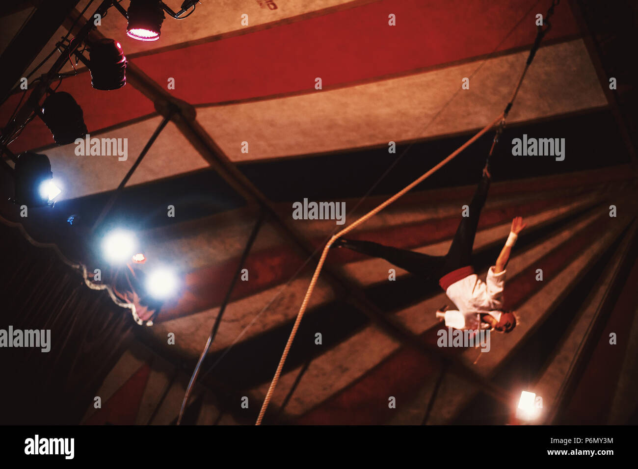 Scena da un circo play, una femmina acrobat sulla fune in blur, con focus su riflettori di luce. Foto Stock