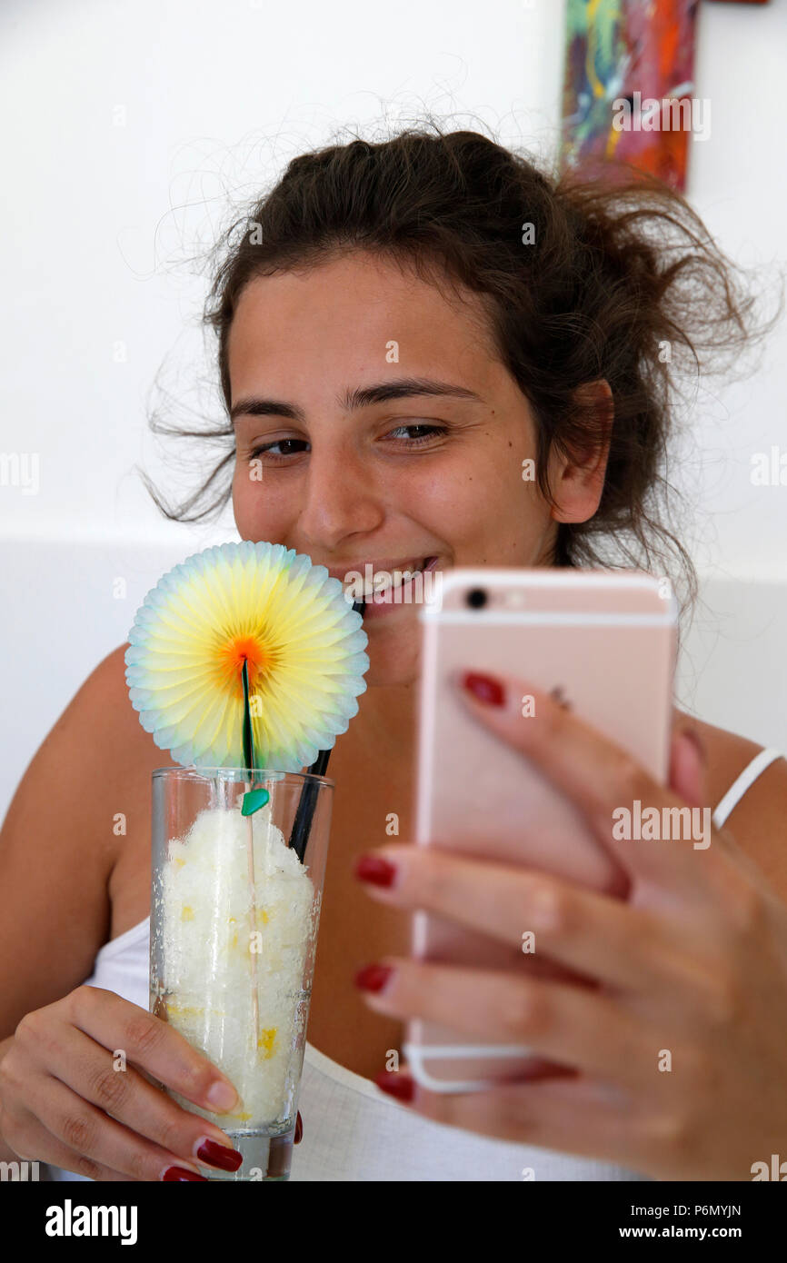 Giovane donna prendendo un selfie mentre mangia una granita nel salento, Italia Foto Stock