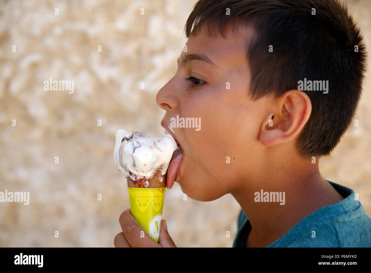 11-anno-vecchio ragazzo di mangiare un gelato nel Salento, Italia. Foto Stock